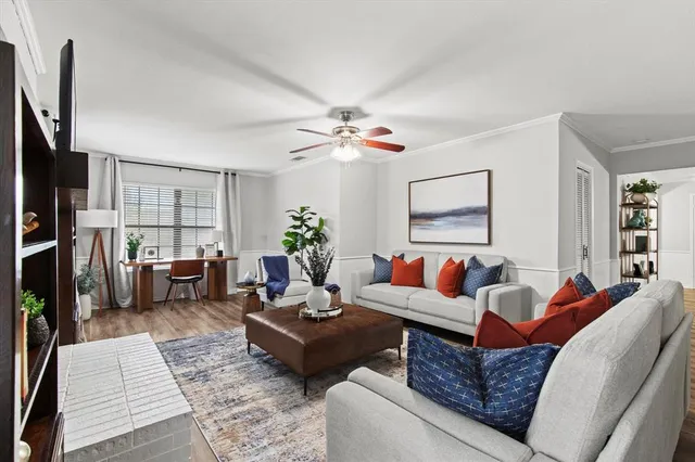 a living room with furniture a flat screen tv and a window