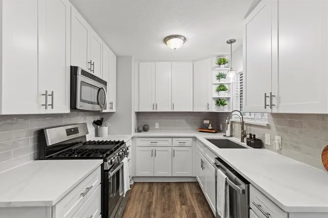 a kitchen with a sink stove top oven and cabinets