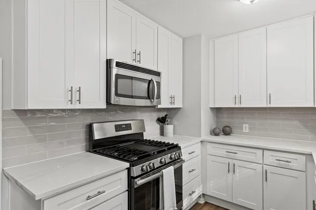 a kitchen with white cabinets and white appliances