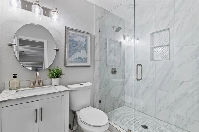 a bathroom with a toilet a sink and glass door