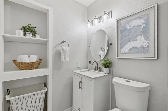 a bathroom with a toilet a sink and mirror