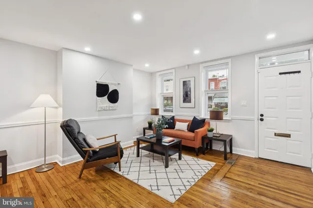 a living room with furniture and a wooden floor