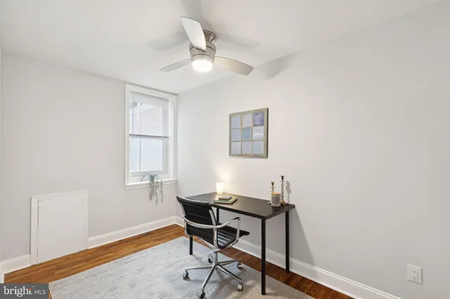 a view of a workspace with furniture and a window