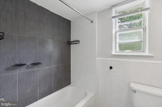 a bathroom with a bathtub a toilet and a shower