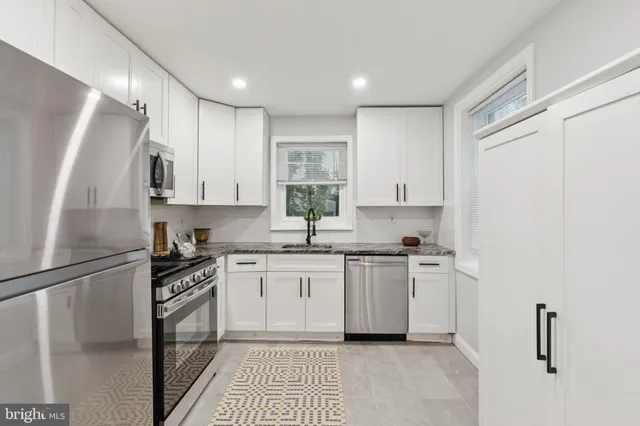 a kitchen with stainless steel appliances granite countertop a refrigerator sink and stove