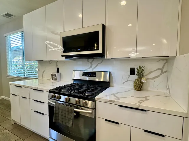 a kitchen with stainless steel appliances granite countertop a sink a stove a microwave and cabinets