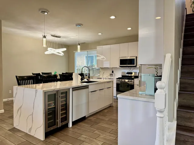 a kitchen with a sink stainless steel appliances and white cabinets