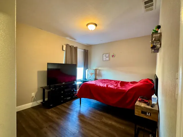 a living room with a bed furniture and a flat screen tv