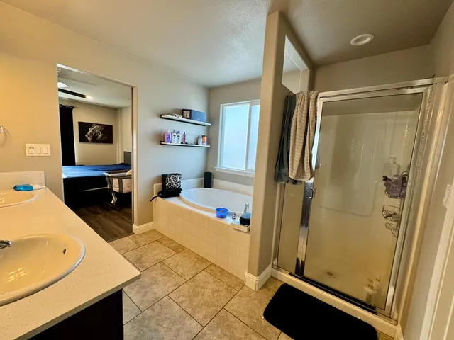 a spacious bathroom with a double vanity sink mirror and bathtub