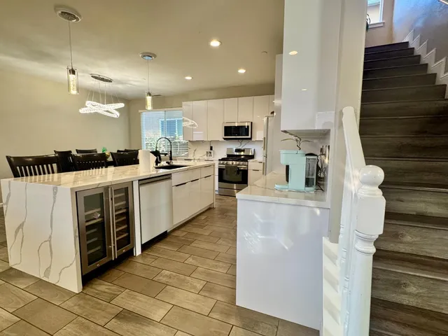 a kitchen with stainless steel appliances a stove a microwave a sink a refrigerator and white cabinets