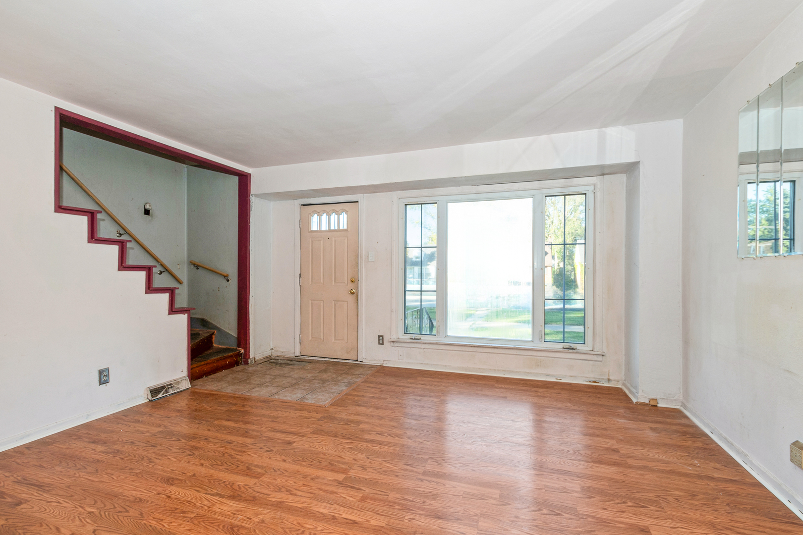 1473 Wentworth Avenue Calumet City, IL 60409 - Photo 4 of 18 a view of an empty room with wooden floor and a window