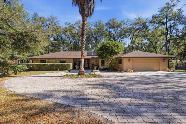 a front view of a house with a yard and trees