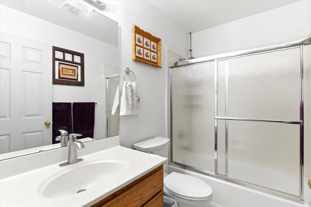 72 Canal Bank Road Garland, UT 84312 - Photo 18 of 40 Bathroom featuring a wood-finish vanity with a white countertop and integrated sink, brushed nickel faucet, and a large wall-mounted mirror