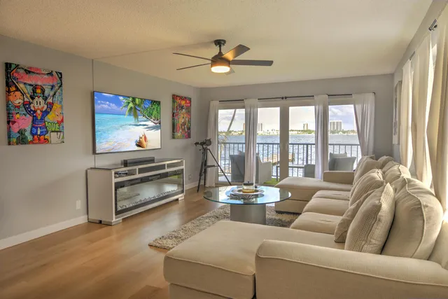 a view of a dining room with furniture one side kitchen view and wooden floor