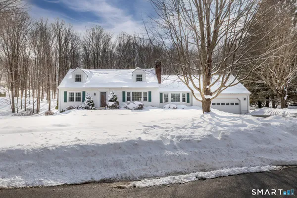a front view of a house with a yard covered in snow