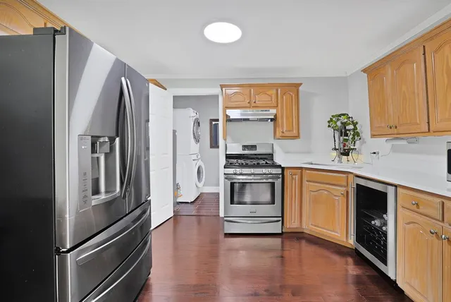 a kitchen with granite countertop a refrigerator stove and sink