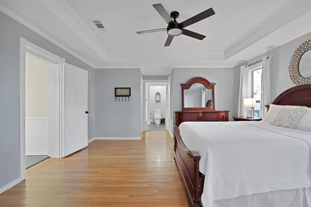 a bedroom with a large bed and a chandelier
