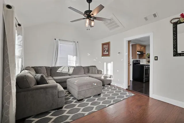 a living room with furniture and a ceiling fan