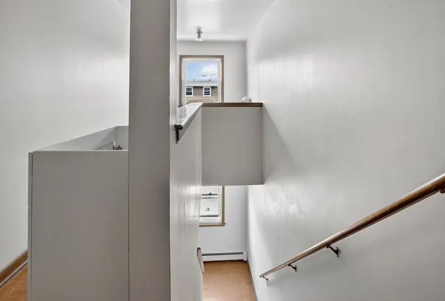 a view of a hallway with wooden floor and staircase
