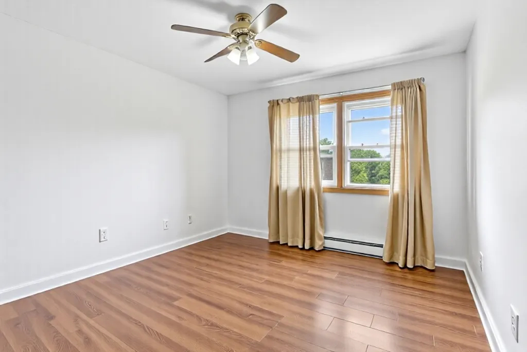 7048 O'Connell Drive, Unit 3W Chicago Ridge, IL 60415 - Photo 17 of 22 an empty room with wooden floor and windows