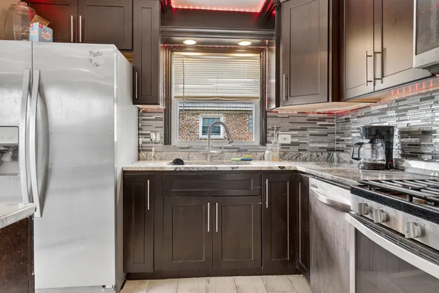 a kitchen with stainless steel appliances granite countertop a refrigerator and a sink