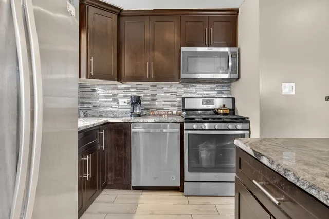 a kitchen with stainless steel appliances granite countertop a stove and a microwave