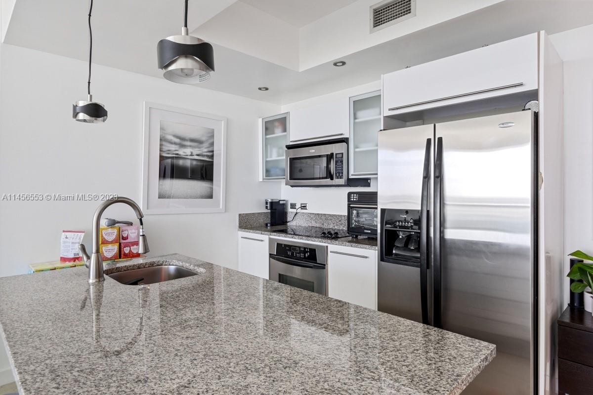 888 Biscayne Boulevard, Unit 1809 Miami, FL 33132 - Photo 11 of 37 a kitchen with kitchen island a counter top space appliances and cabinets