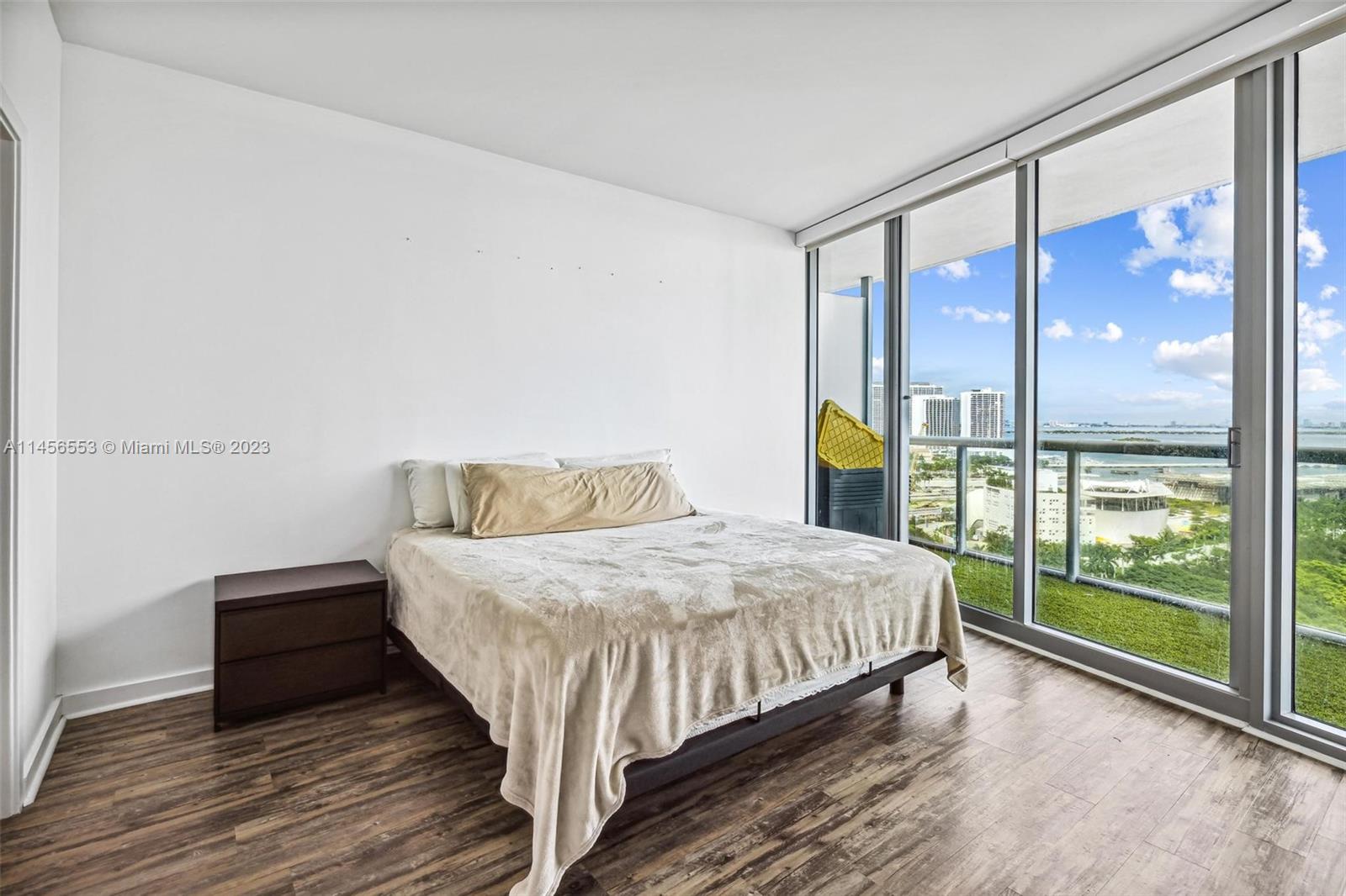 888 Biscayne Boulevard, Unit 1809 Miami, FL 33132 - Photo 16 of 37 a bedroom with a bed and a large window