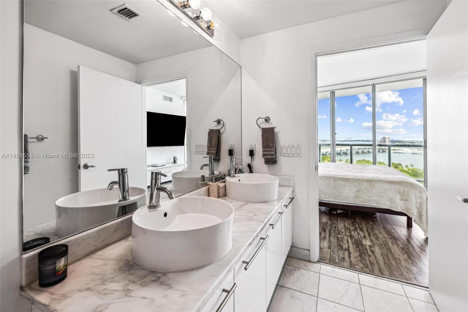 888 Biscayne Boulevard, Unit 1809 Miami, FL 33132 - Photo 17 of 37 a bathroom with a toilet sink and mirror
