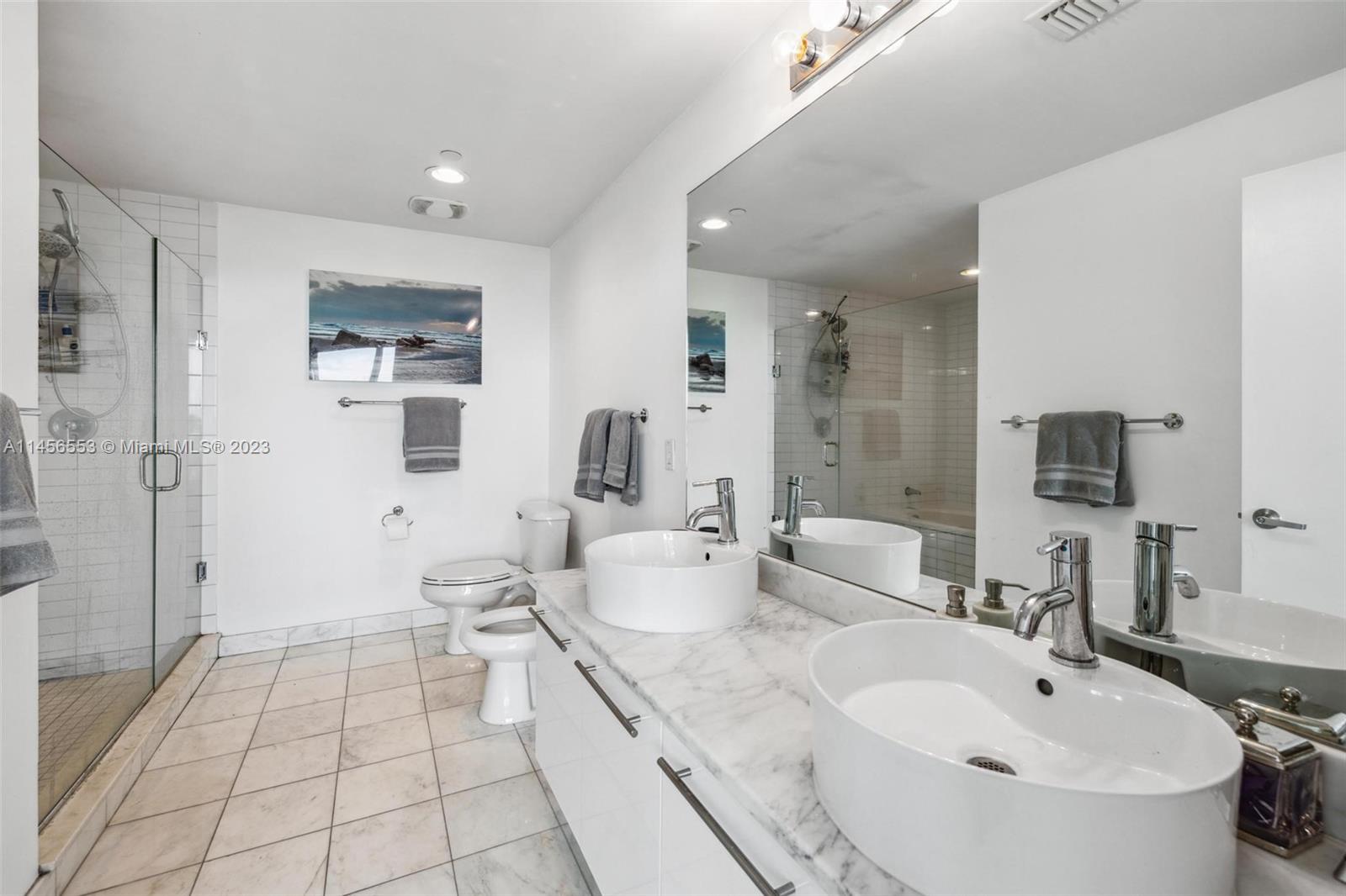 888 Biscayne Boulevard, Unit 1809 Miami, FL 33132 - Photo 18 of 37 a spacious bathroom with a double vanity sink a mirror and a bathtub