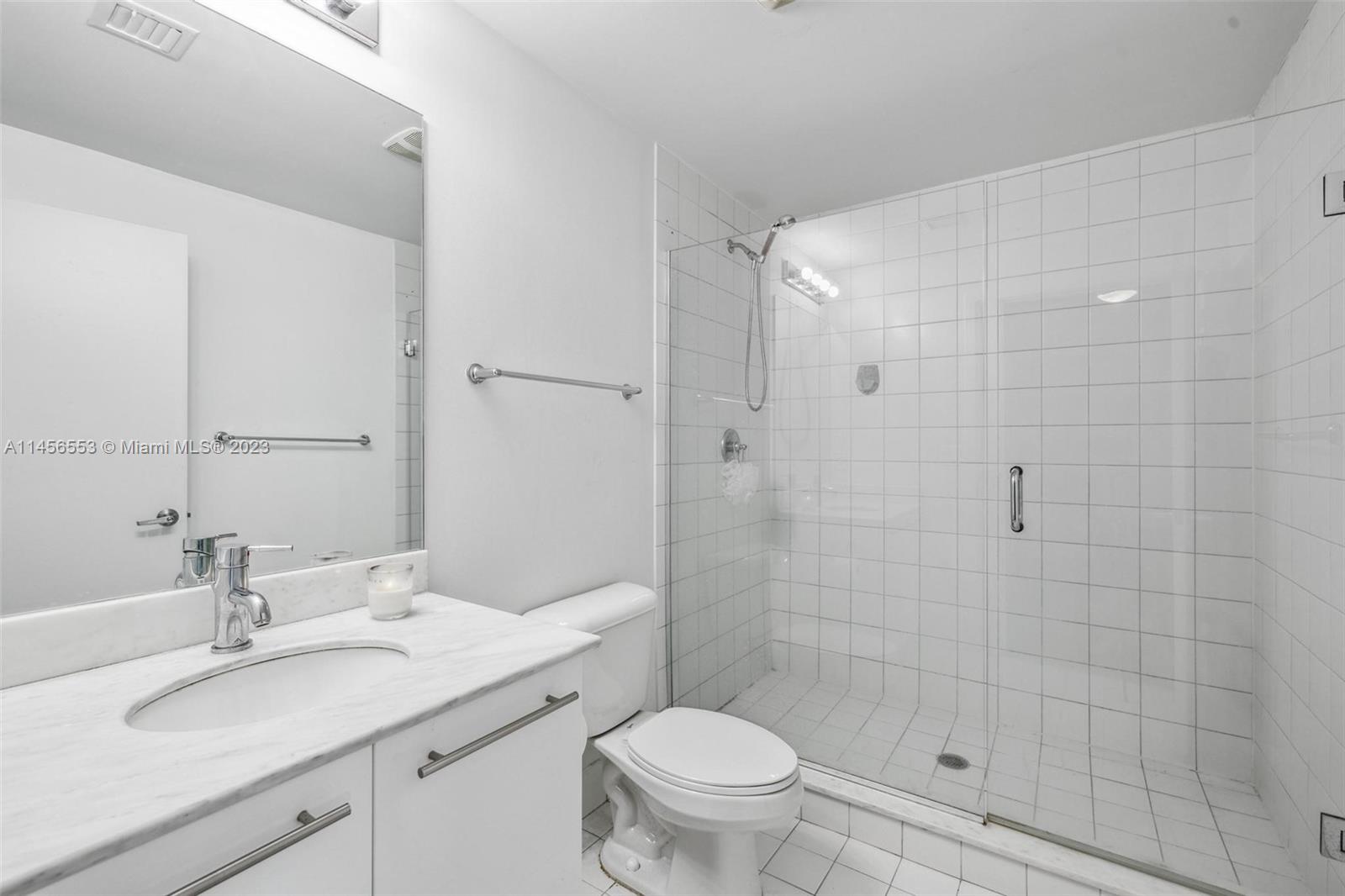 888 Biscayne Boulevard, Unit 1809 Miami, FL 33132 - Photo 22 of 37 a bathroom with a sink toilet vanity and shower
