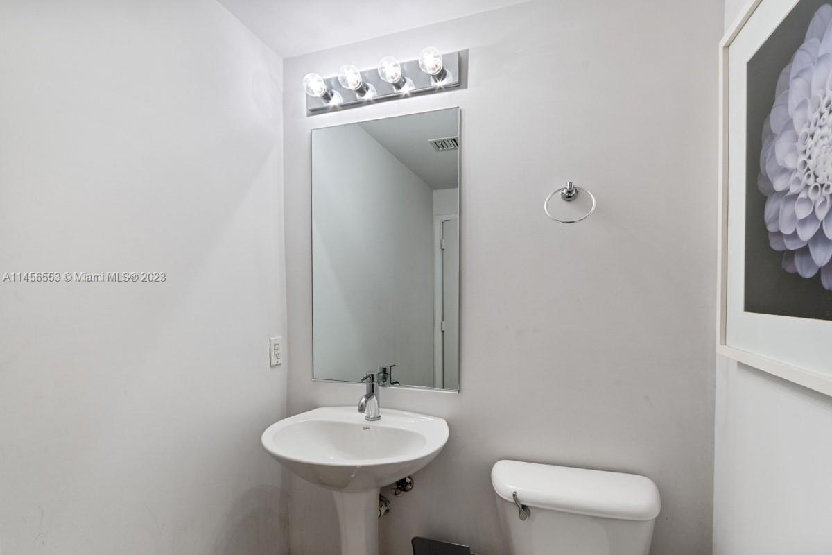 888 Biscayne Boulevard, Unit 1809 Miami, FL 33132 - Photo 23 of 37 a bathroom with a toilet sink and mirror