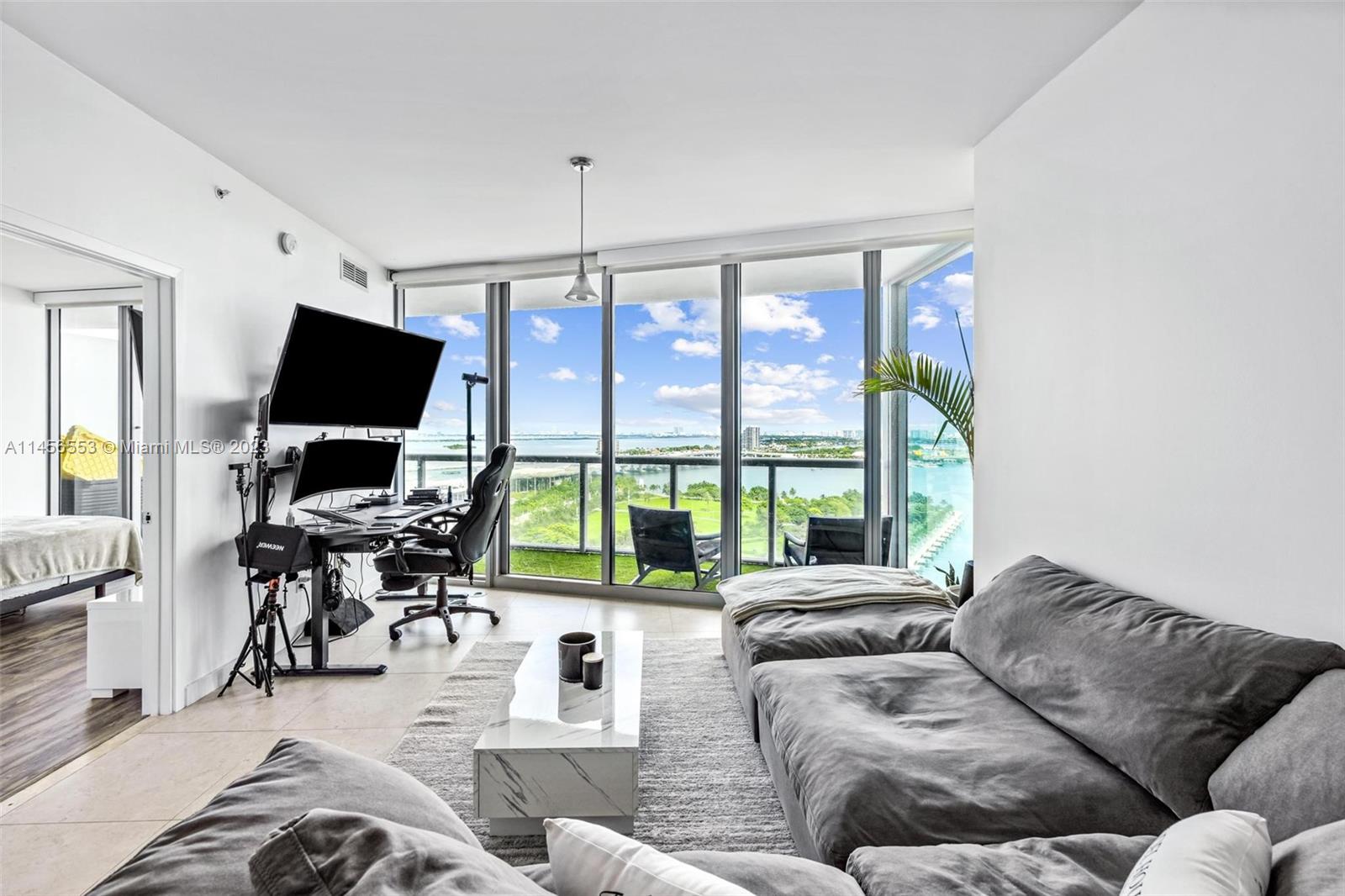 888 Biscayne Boulevard, Unit 1809 Miami, FL 33132 - Photo 36 of 37 a living room with furniture flat screen tv and a large window