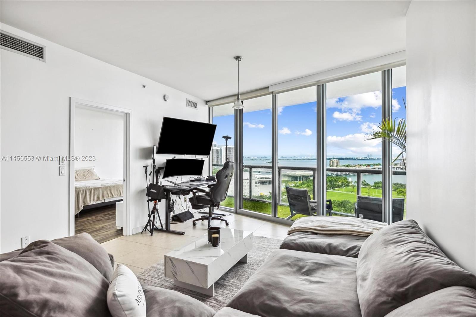 888 Biscayne Boulevard, Unit 1809 Miami, FL 33132 - Photo 37 of 37 a living room with furniture a large window and a flat screen tv