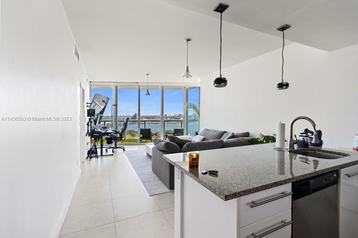888 Biscayne Boulevard, Unit 1809 Miami, FL 33132 - Photo 9 of 37 a kitchen with a sink a kitchen island a stove and a cabinets