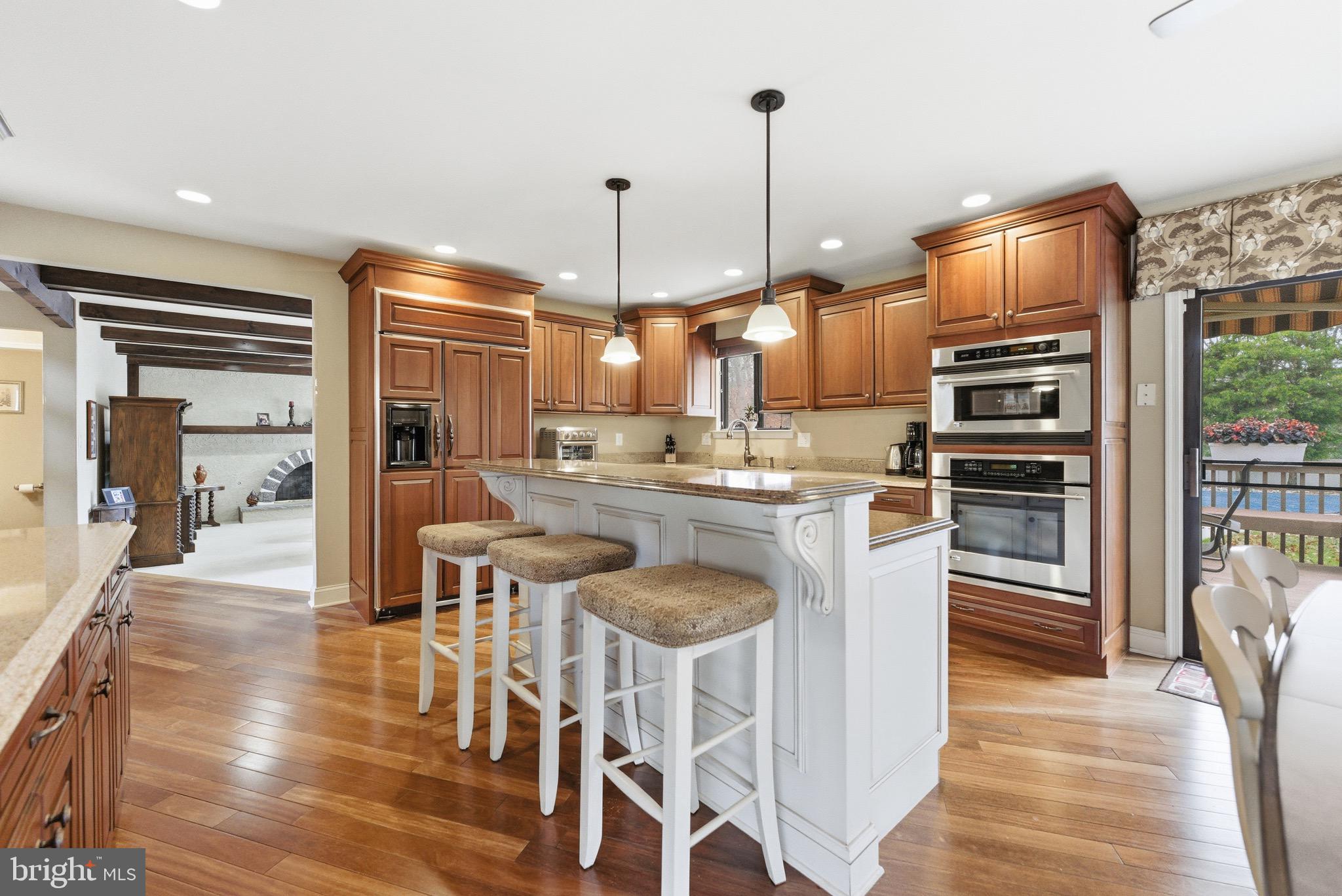 3 Stonehurst Drive Voorhees, NJ 08043 - Photo 5 of 43 a kitchen with stainless steel appliances kitchen island granite countertop a refrigerator a stove a kitchen island with chairs and wooden floor