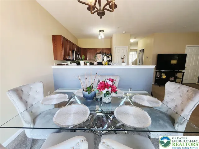 a kitchen with stainless steel appliances kitchen island granite countertop a dining table chairs and a coffee table