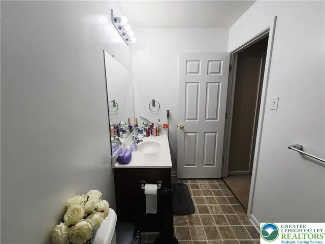 a bathroom with a sink and mirror with bathtub