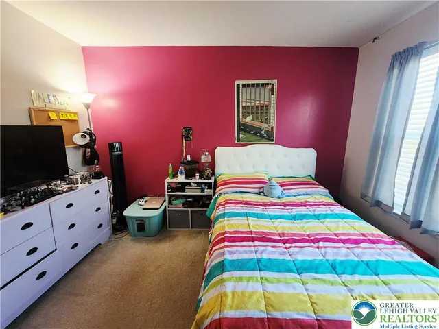 a room that has a bed and a flat screen tv on the dresser