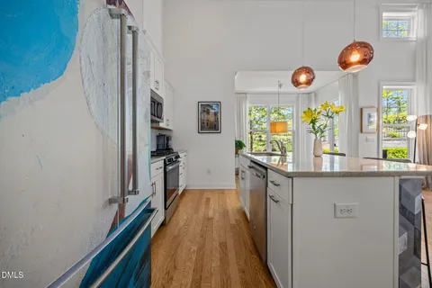 a view of a dining room and kitchen with furniture wooden floor and a rug