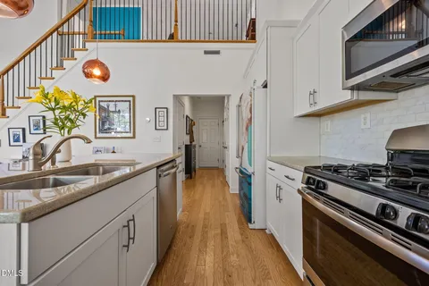 a kitchen with stainless steel appliances a large window a sink and a refrigerator
