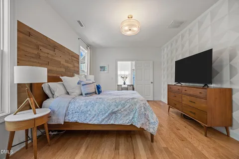 a bedroom with a bed and wooden floor
