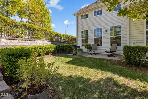a view of a chair and table in backyard of the house