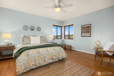 a bedroom with bed and wooden floor