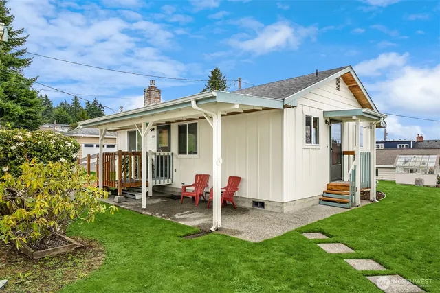 a backyard of a house with table and chairs
