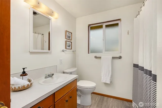 a bathroom with a granite countertop sink toilet and mirror