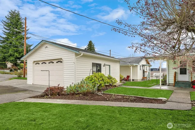 a front view of a house with a yard and potted plants