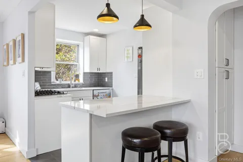 a kitchen with stainless steel appliances a sink a stove and a refrigerator with wooden floor