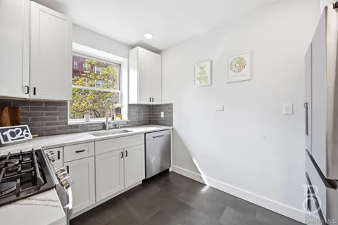 a kitchen with white cabinets and window