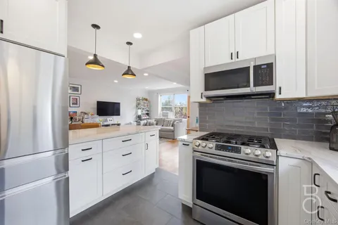 a kitchen with stainless steel appliances white cabinets and a stove a oven with white countertops